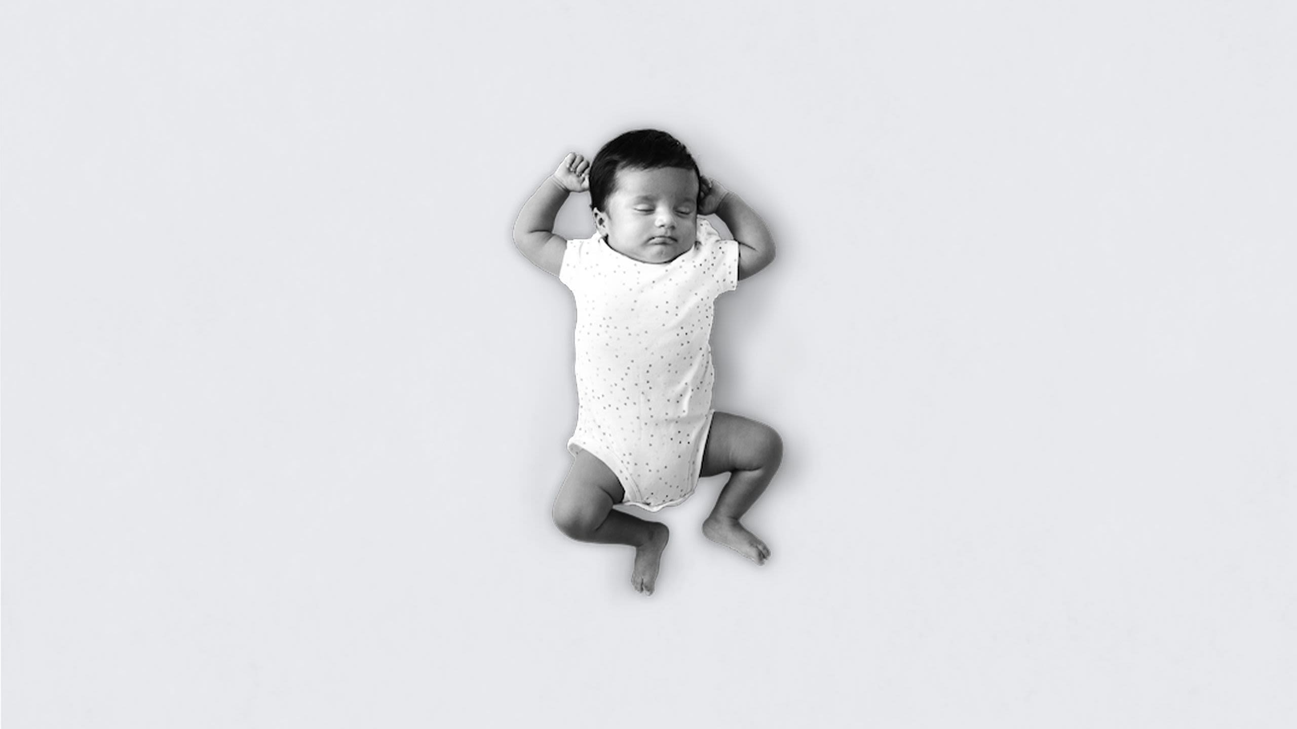 black and white image of young baby asleep named ishaan