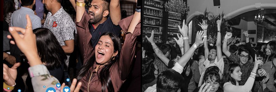 group scene of ishaan partying with their hands in the air celebrating in a bar