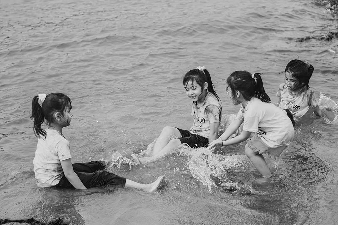 black and white image of children playing happily in a rivew