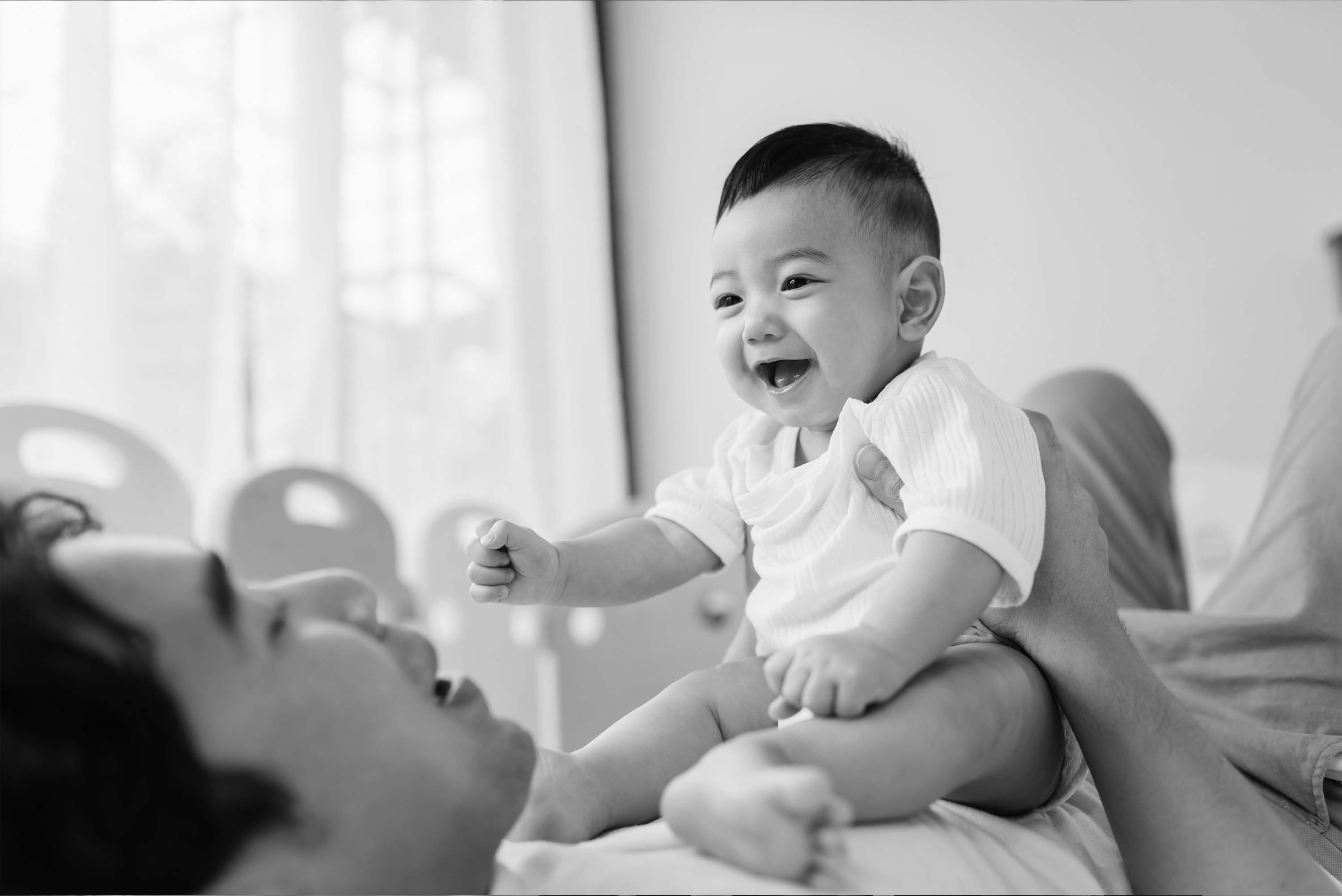 black and white image of a man holding a young cute baby