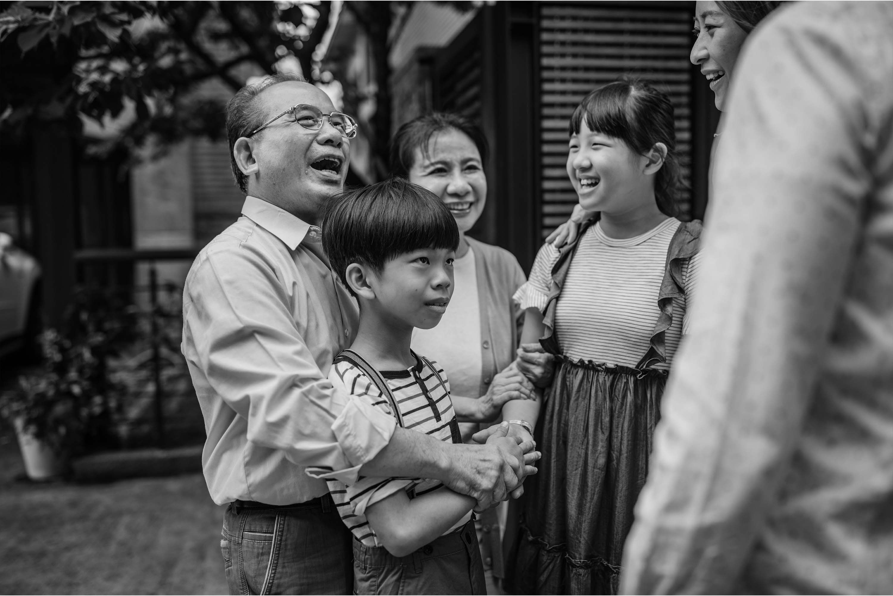 black and white image of older man surrounded by family
