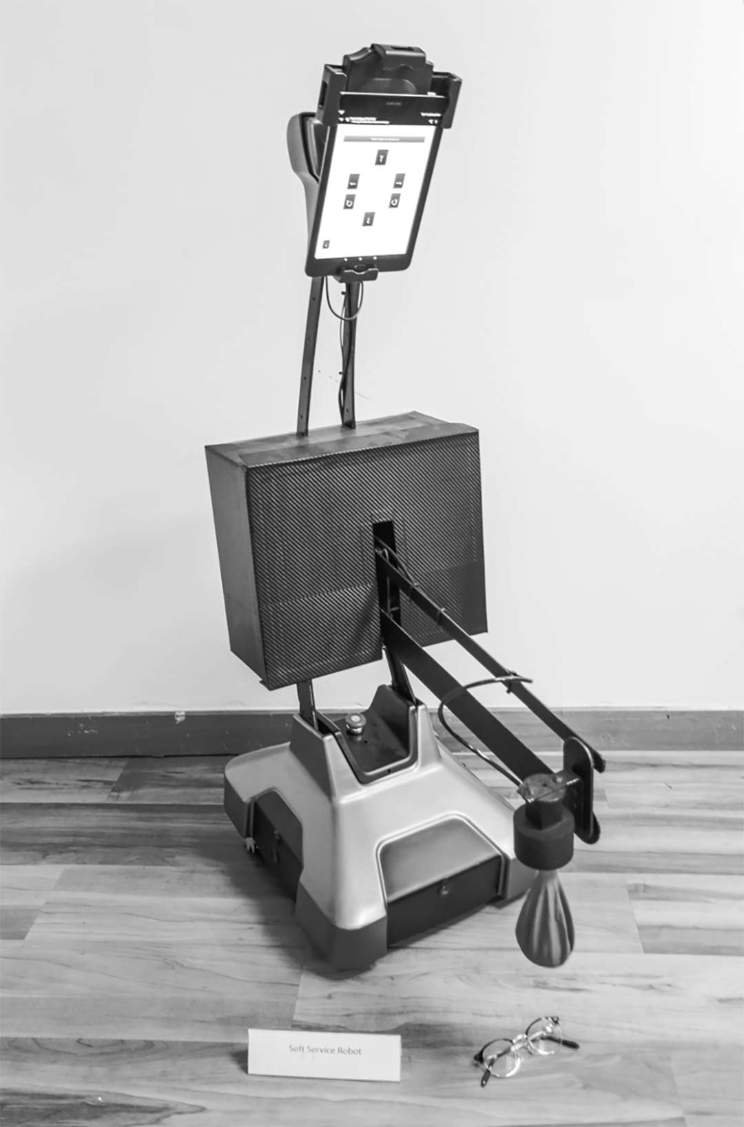 black and white image of a mobile robot with an ipad attached