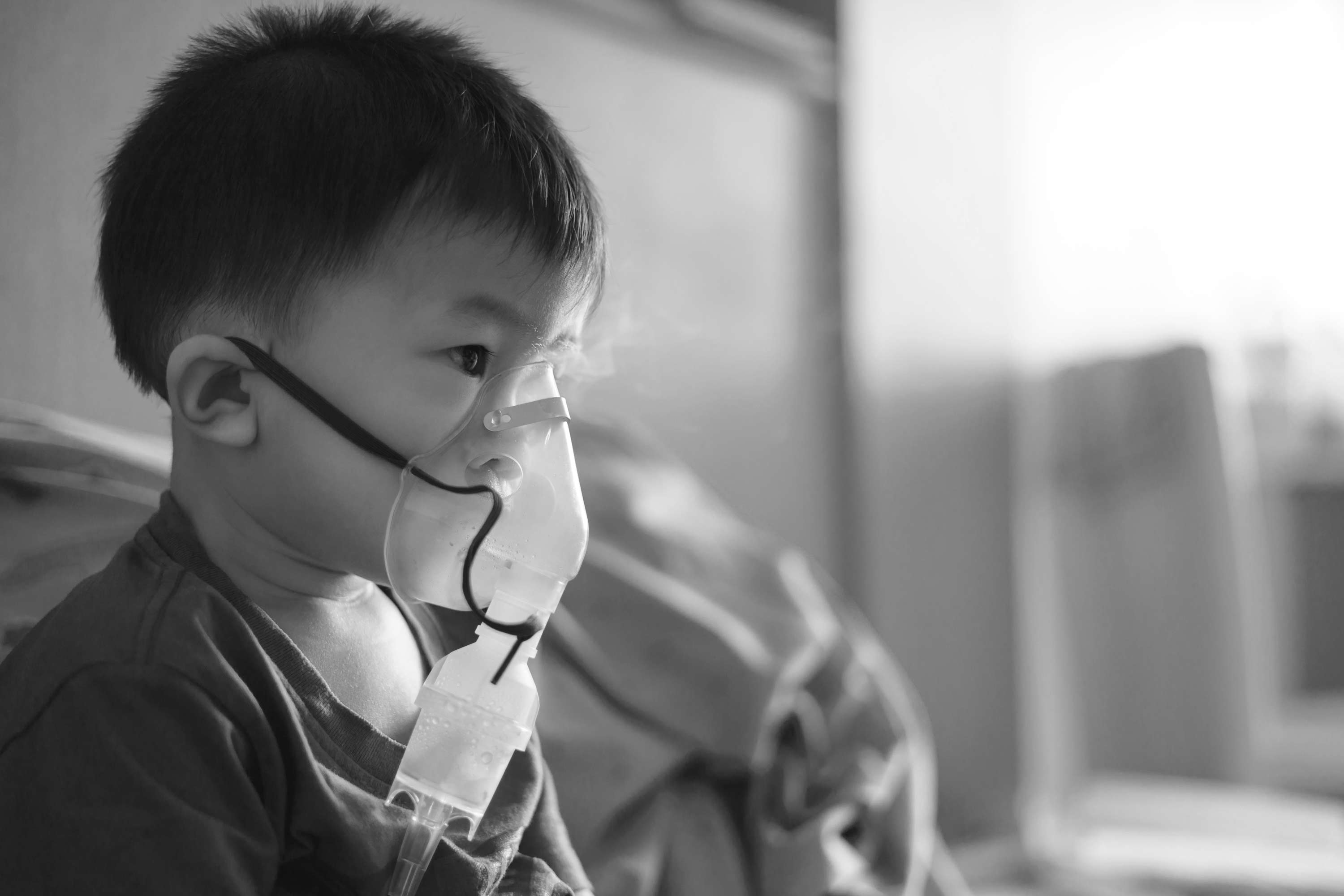 black and white image of samroze with a oxygen mask on his face in a hospital