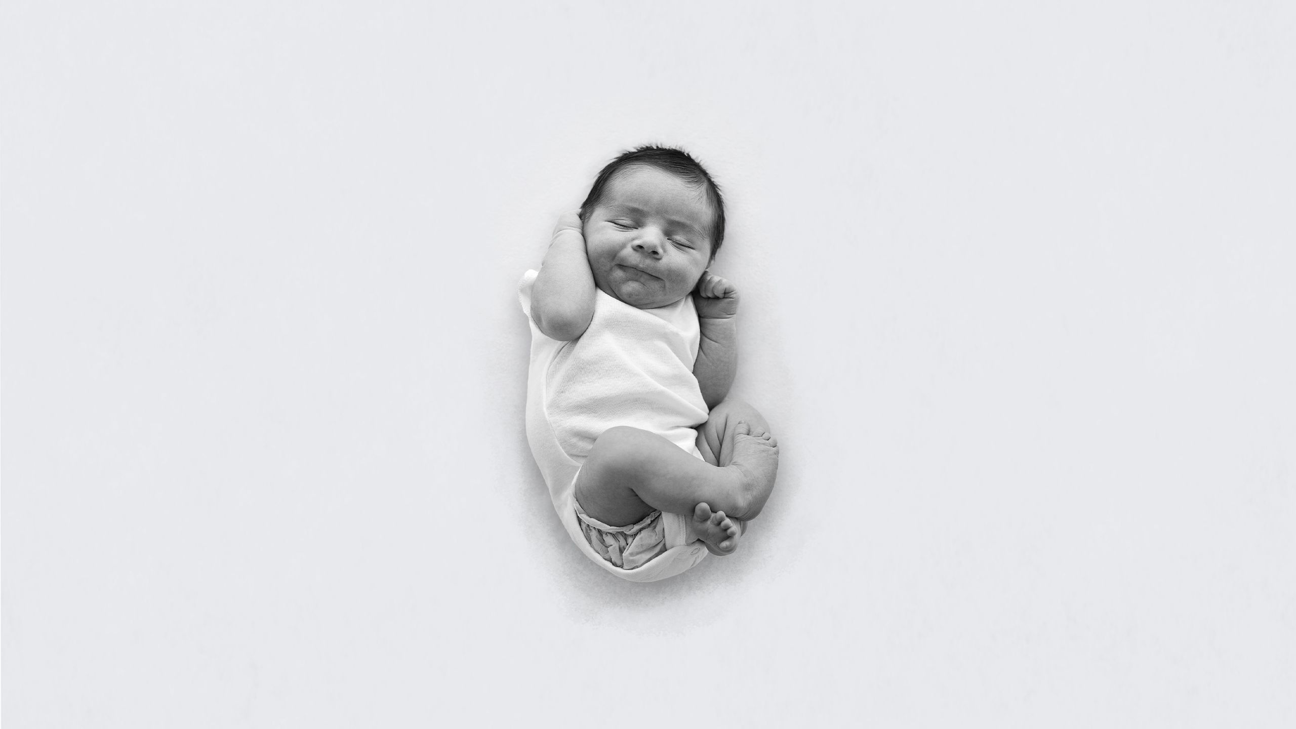 black and white image of small baby Tait curled up named tait