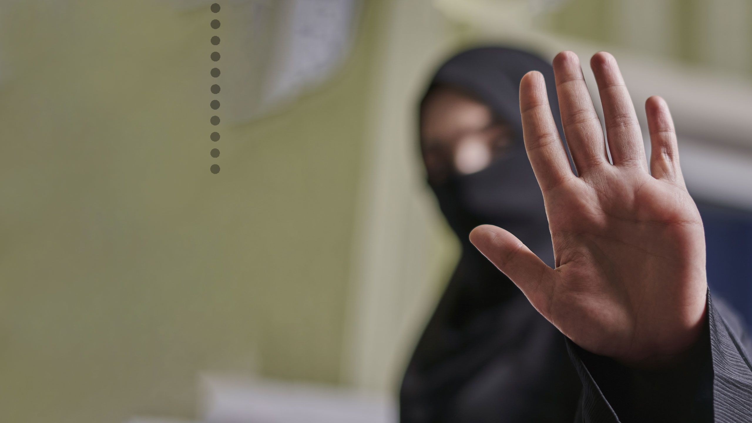 Middle Eastern women holding up hand in stop sign